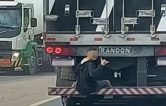 Homem é flagrado se segurando na traseira de caminhão e fazendo 